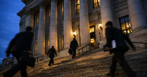 New York City government building entrance at dusk with silhouetted figures on steps in motion