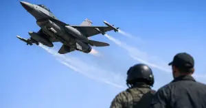 F-16 Fighting Falcon fighter jet banking through clear blue sky during training flight