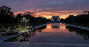 Lincoln Memorial Reflecting Pool during renovation with construction equipment and protective sheeting at dusk