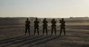 Military firing squad formation silhouetted at dawn on Fort Hood training grounds with rifles at ready