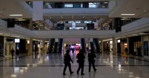FBI tactical team silhouettes moving through empty shopping mall interior with emergency lights reflecting on floors
